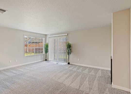 an empty living room with white walls and a window