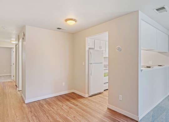 Wood floor hallway with laundry and linen closet leading to carpeted bedroom with kitchen on right side.at Capitol Crossing, Olympia, WA 98501