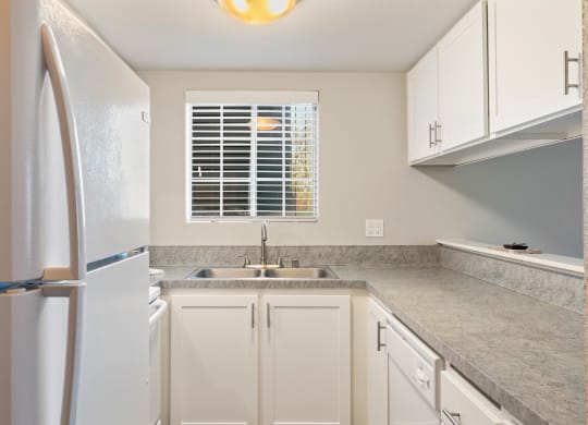 a kitchen with white cabinets and a sink and a refrigerator