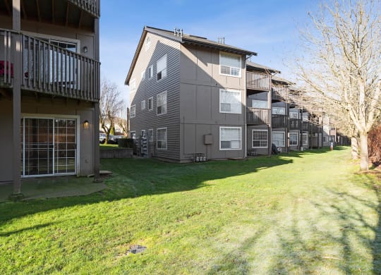 Exterior of Capitol Crossing Apartments with balconies and patios lined with green grass and trees.at Capitol Crossing, Washington
