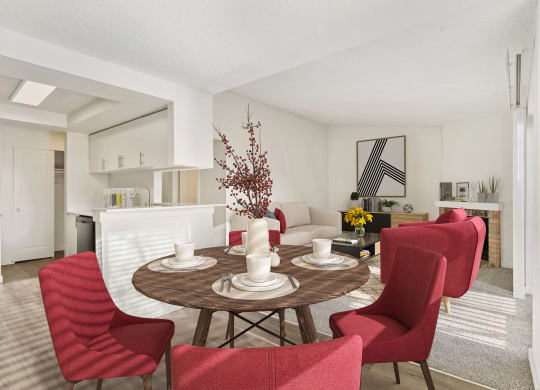 Dining area with white walls and the kitchen is to the left, and the living room is to the right. Staged with a round table and 4 red chairs. at Pointe East, Washington, 98424
