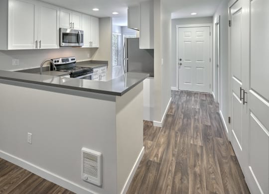a renovated kitchen with white cabinets and stainless steel appliances at Edmonds Gateway, Edmonds, WA 98026