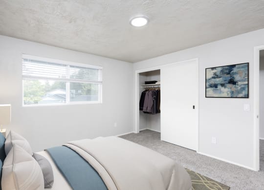 a bedroom with a bed and a closet and a window