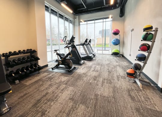 a gym with cardio machines and weights on the floor at The Duo, University Place