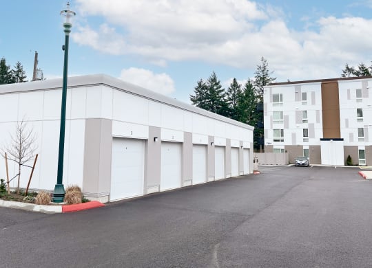 The Duo tenant garages with a parking lot in front of them at The Duo, University Place, 98466
