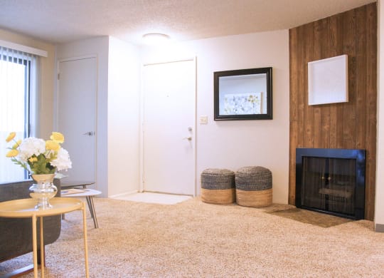 Carpeted living room with fireplace. Sliding doors to patio and staged with living room furniture.at The Lakes Apartments, Moses Lake
