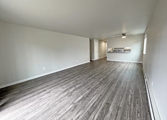 Living room looks to the kitchen with a long breakfast bar, a large window on the left wall, and a hallway on the right.at Quilceda Gardens, Marysville, WA 98270