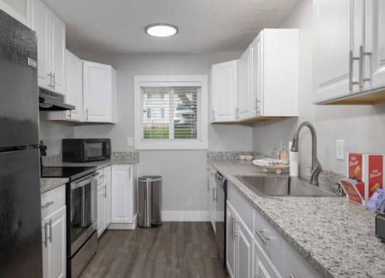 a kitchen with granite counter tops and white cabinets  at Kirkwood Meadows, Pocatello