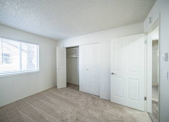 an empty bedroom with a closet and a window at Kirkwood in Pocatello, ID