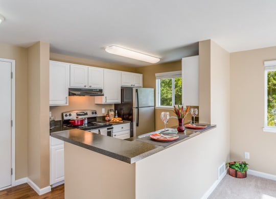 a kitchen with a island and a stove and a refrigerator at Springfield, Renton, 98055
