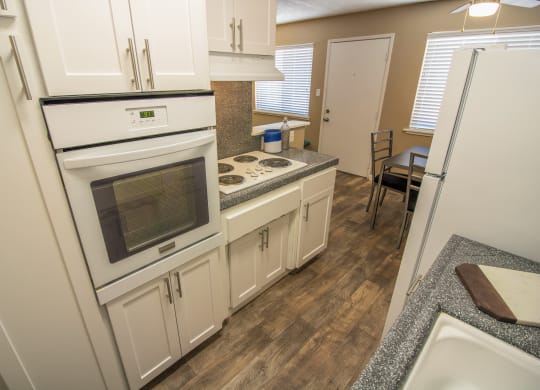 kitchen with new white cabinets and gray faux granite countertops, with dining area visible in the distance at Woodland Village Apartments , California, 95695
