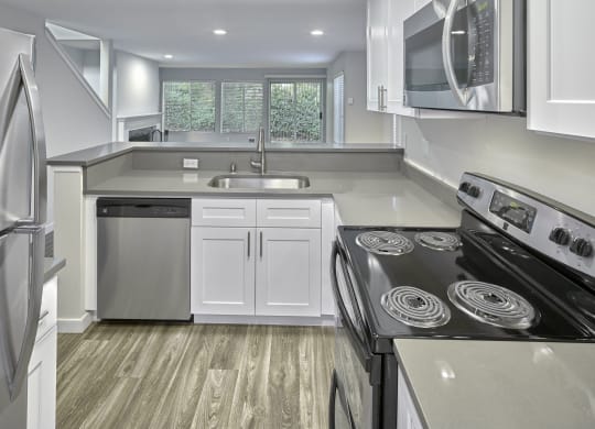 a kitchen with white cabinets and a stove and a microwave at Edmonds Gateway, Edmonds, 98026