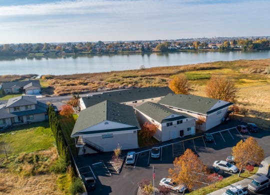 Aerial view of the community with grass fields leading to Moses Lake behind The Lakes Apartments.at The Lakes Apartments, Moses Lake