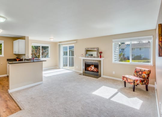 an empty living room with a fireplace and a kitchen at Springfield, Renton, WA 