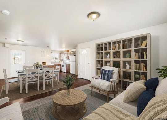 Spacious living room opens into the dining area with a door to the balcony. Staged with couch, coffee table, and 2 chairs. at Pine Tree Park, Kennewick, WA