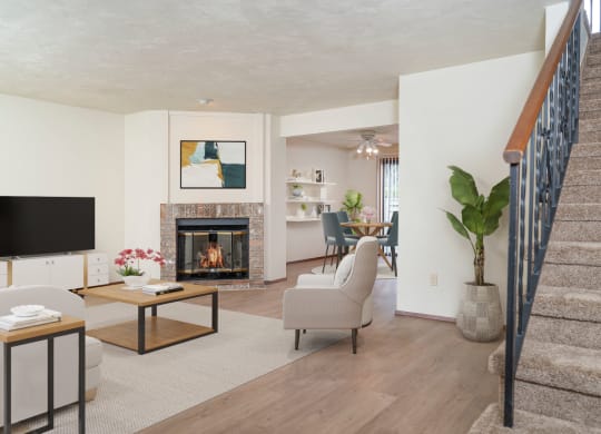 Oversized living room with brick fireplace in the center, staged with couch, chair, media console, TV, and plant. at Hawks Prairie, Olympia, 98516