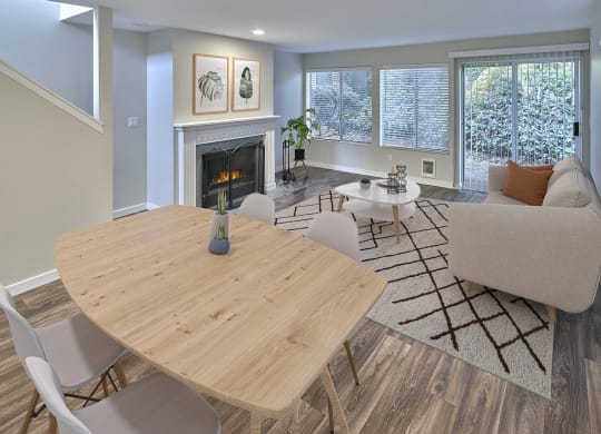 Living and Dining open layout with a fireplace, lots of windows and finished with a small dining set, coffee table and couch.at Edmonds Gateway, Edmonds, 98026