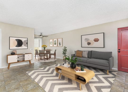 Apartment living room showing the entry door, large couch, coffee table and the dining area at Pacific Sands, San Diego, CA