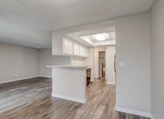 A dining area looks into the kitchen and living room with wood flooring and lots of natural light. at Pointe East, Washington