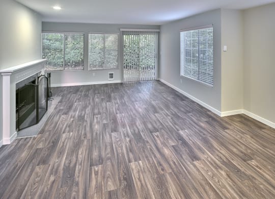 an empty living room with a fireplace and wooden floors at Edmonds Gateway, Washington