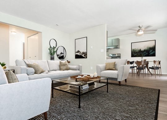 Living room with couch, two chairs, and coffee table.  Dining room visible in the back at University Glen, Washington