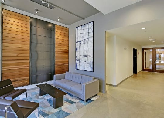 Lobby with laminate flooring, tall ceiling and art. Furnished with couch, 2 chairs and coffee table.at 19th & Mercer, Seattle, WA