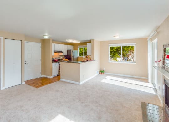 an empty living room with a kitchen and a window at Springfield, Renton
