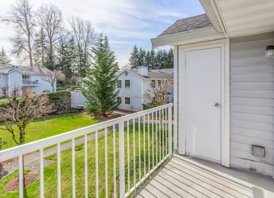 the view of the yard from the balcony of a home with a white door  at Springfield, Renton, WA, 98055
