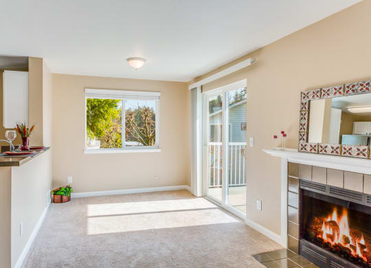 an empty living room with a fireplace and a balcony  at Springfield, Renton, WA