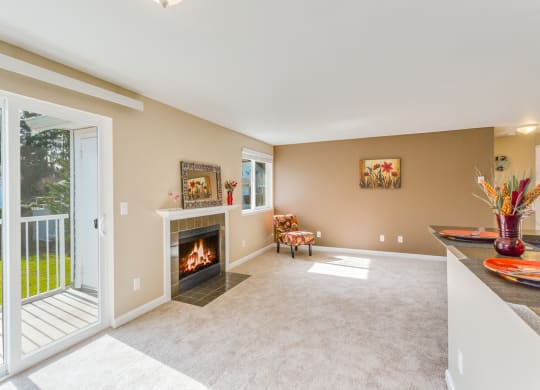 a living room with a fireplace and a balcony at Springfield, Renton, WA 98055