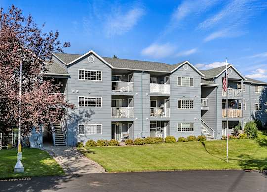 Exterior of The Overlook Apartments in Post Falls with American flag and multiple residential buildings.