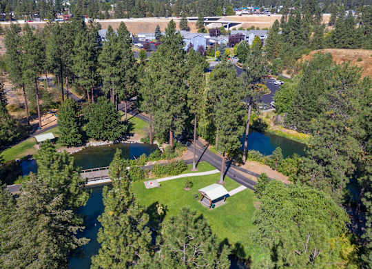 View of The Overlook Apartments in Post Falls with mature trees, and mountains in the distance.