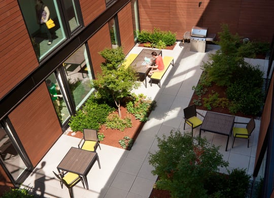 Exterior view of community. Beautiful landscaping with seating areas, a community grill and pathways to the building.at 19th & Mercer, Seattle