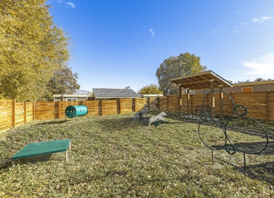 Large grassy dog run area with fence and tunnels at Park View Apartments, Wenatchee Washington