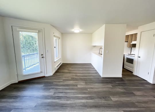 an empty living room and kitchen with white walls and wood flooring  at The Trail, Snohomish