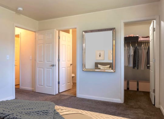 Carpeted bedroom with ensuite on the back left wall and large closet to the right with shelving. at Pine Tree Park, Kennewick, 99337