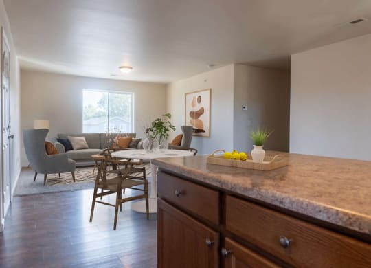 Kitchen breakfast bar looks into the dining area and living room filled with natural light. Staged dining set. at Pine Tree Park, Kennewick, WA