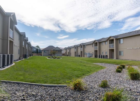 an empty lawn in front of a row of houses