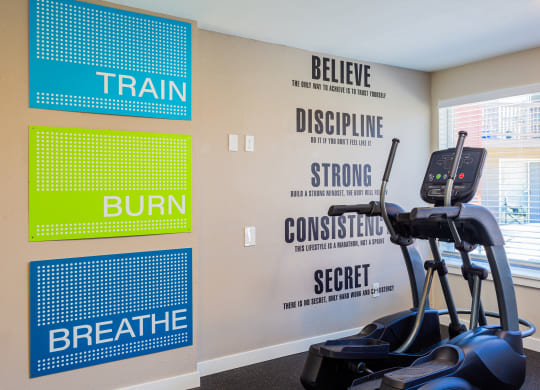 a workout room with a treadmill and motivational signs on the wall