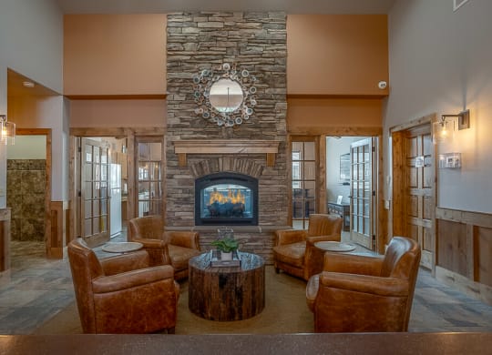 Quail Springs clubhouse with large stone fire place and 4 leather chairs
