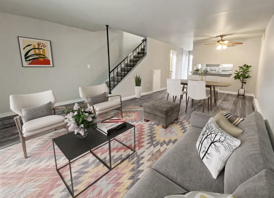 Bright open living room with carpeted stairs to the left and dining area on the right. Wood-style floors and ceiling fan.at Quilceda Gardens, Marysville, Washington