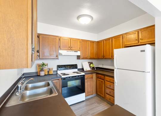 A kitchen with wooden cabinets and a white refrigerator.