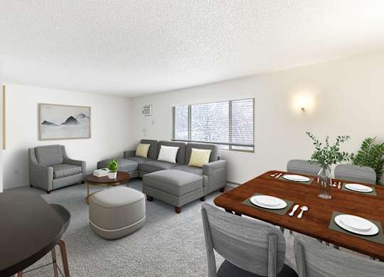 A modern living room with grey furniture and a wooden dining table at Rock Creek Apartments in Billings, MT.