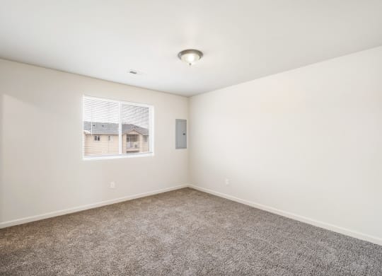 Clean, bright bedroom with taupe carpet, white walls and a large window in one wall. at Pine Tree Park, Washington, 99337