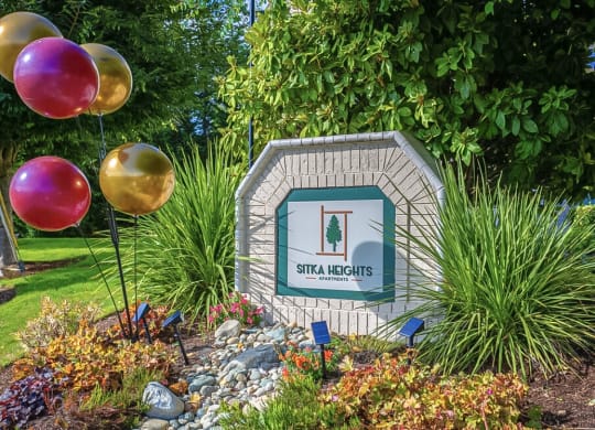 a sign in a garden with balloons  at Sitka Heights, Fife, WA