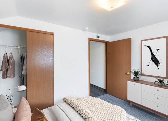 A bedroom with a large closet, dresser and painting at Shiloh Glen Apartments in Billings, MT.