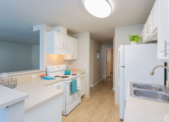 a kitchen with white cabinets and a stove and a refrigerator at Sitka Heights in Fife
