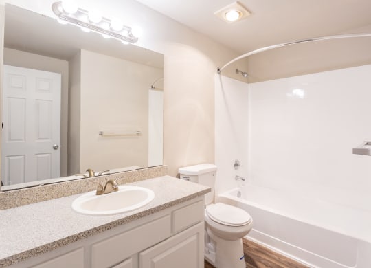 a bathroom with a mirror and a toilet and a sink and a full bathtub at Sitka Heights in Fife