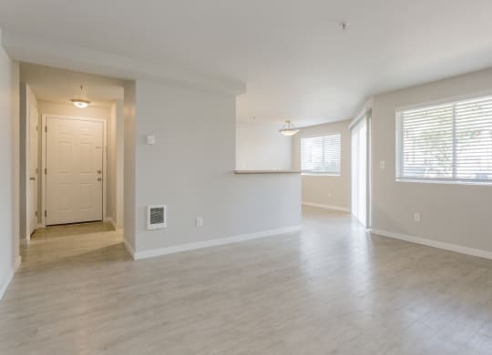the living room and dining room of an empty home with a large window at Sitka Heights in Fife