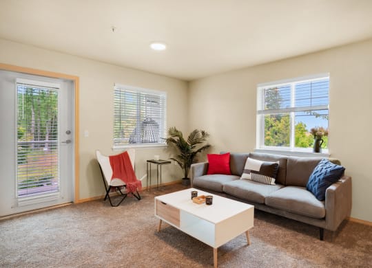 a living room with a couch and a coffee table, two windows and a glass exterior door at Sky Vue, Washington